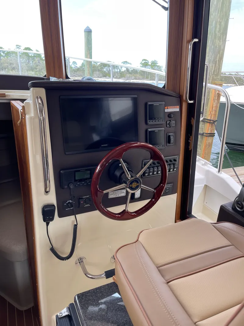 Slide: The Image of 2023 Ranger Tugs R-31 CB helm with modern controls and wooden steering wheel. - 15