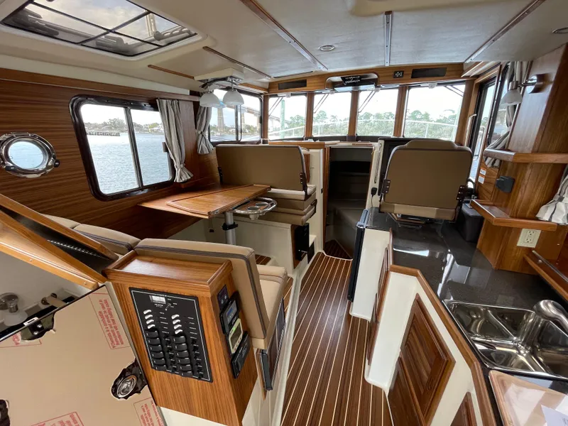 Slide: The Image of 2023 Ranger Tugs R-31 CB interior with wood accents and panoramic windows. - 17