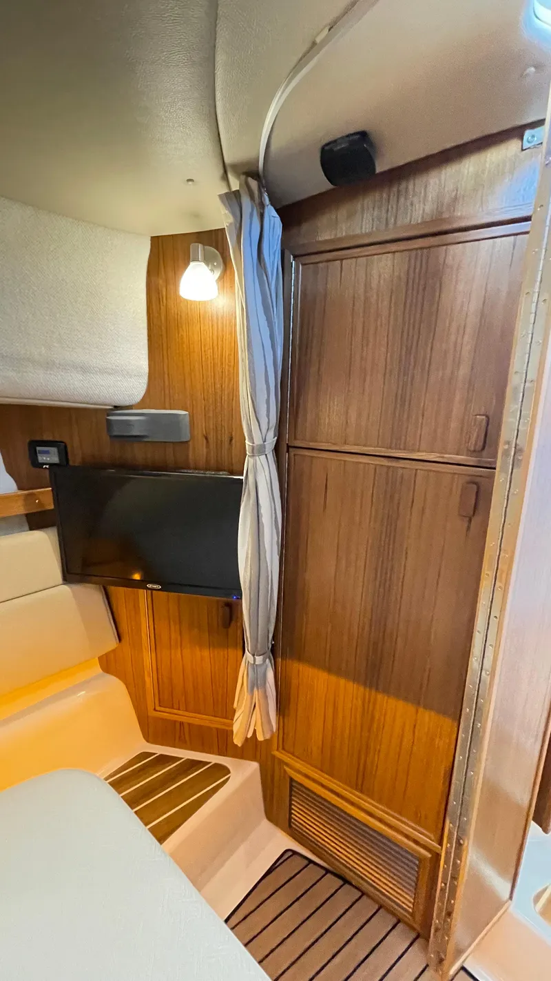 Slide: The Image of 2023 Ranger Tugs R-31 CB cabin interior with wood paneling and mounted TV. - 22