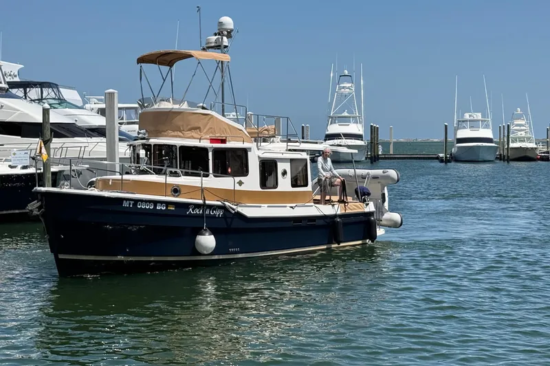 Slide: The Image of 2023 Ranger Tugs R-31 CB boat docked in a marina under clear blue skies. - 3