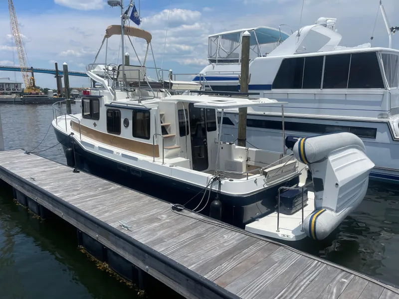 Slide: The Image of 2023 Ranger Tugs R-31 CB docked at marina, featuring sleek design and spacious deck. - 5