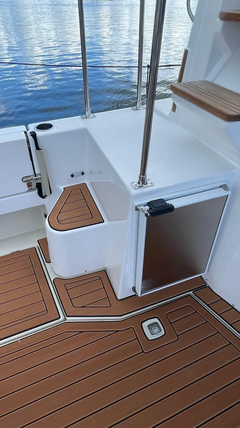 Slide: The Image of 2023 Ranger Tugs R-31 CB boat deck with wood finish and storage compartment. - 8