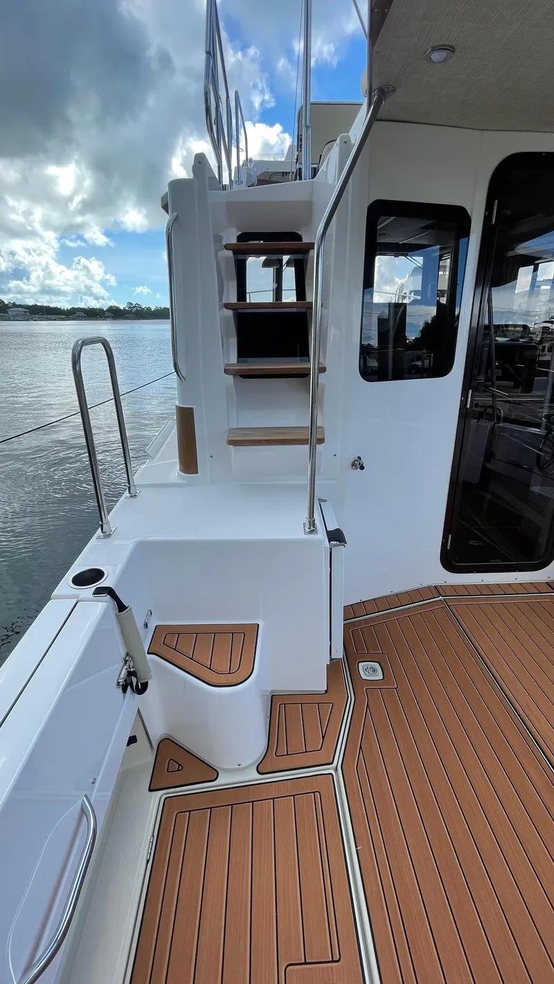 Slide: The Image of 2023 Ranger Tugs R-31 CB boat deck with wooden flooring and stairs. - 9