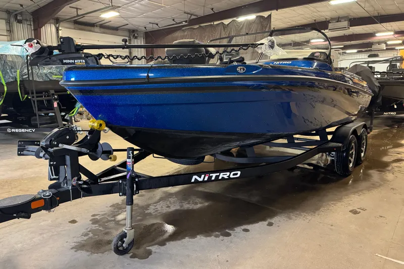 The Image of 2026 Nitro ZV19 Sport boat in a showroom, blue exterior, on a trailer. - 0