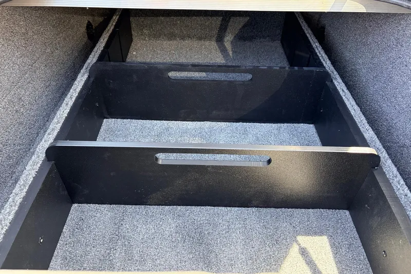 Slide: The Image of 2026 Tracker Pro Team 175 boat storage compartments with carpeted interior and dividers. - 16