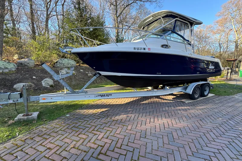 The Image of 2014 Robalo R265 Walkaround boat on trailer, parked on brick driveway. - 0