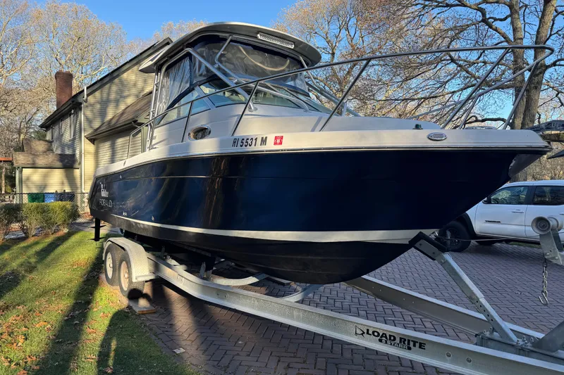 Slide: The Image of 2014 Robalo R265 Walkaround boat on trailer, parked in residential driveway. - 3