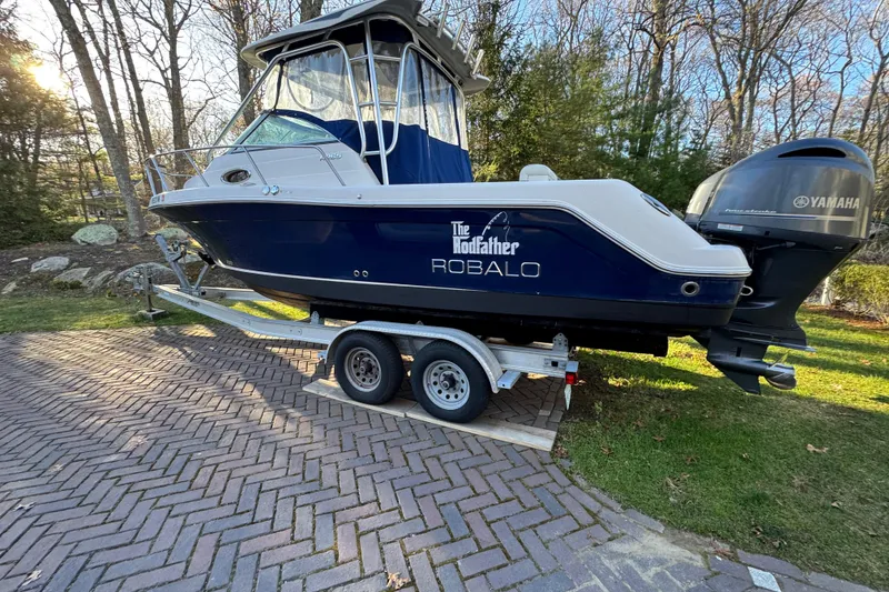 Slide: The Image of 2014 Robalo R265 Walkaround boat on trailer, parked outdoors with Yamaha engine. - 4