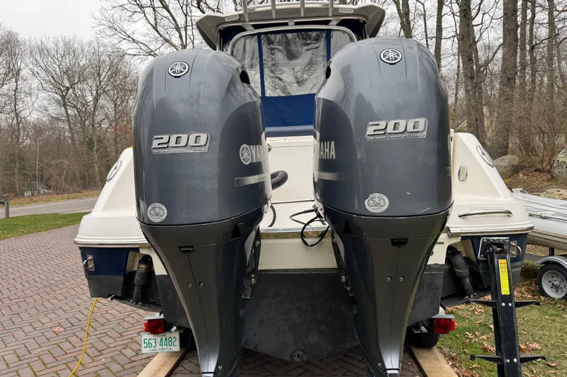 Slide: The Image of 2014 Robalo R265 Walkaround boat with dual Yamaha 200 engines, parked on a brick driveway. - 6