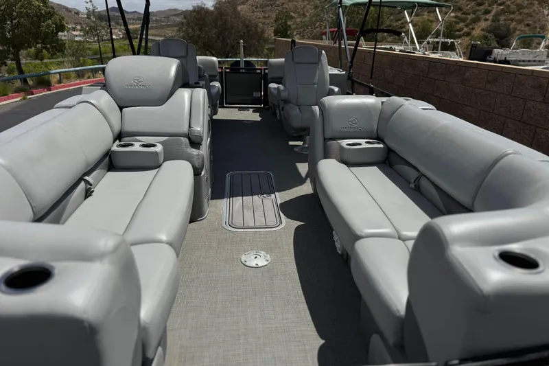 Slide: The Image of 2024 Regency 230 DL3 pontoon boat interior with luxurious gray seating and cup holders. - 10