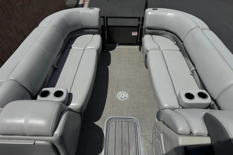 Slide: The Image of 2024 Regency 230 DL3 pontoon boat interior with plush seating and cup holders. - 11