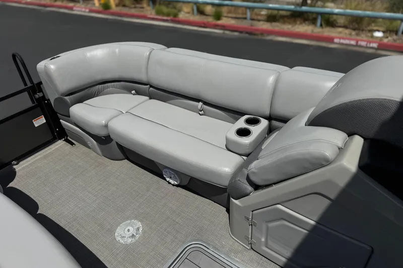 Slide: The Image of 2024 Regency 230 DL3 pontoon boat interior with gray seating and cup holders. - 14