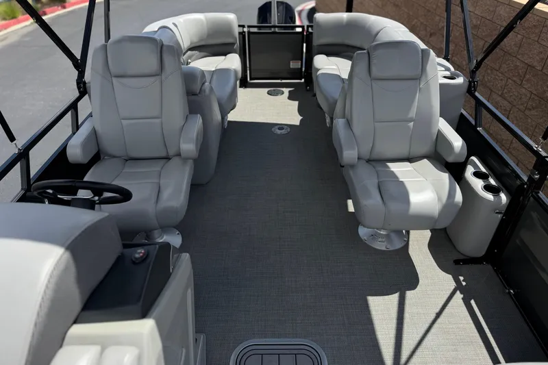 Slide: The Image of 2024 Regency 230 DL3 pontoon boat interior with plush gray seating and spacious layout. - 16