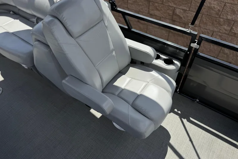 Slide: The Image of 2024 Regency 230 DL3 boat seat with cup holders, featuring luxurious gray upholstery. - 18
