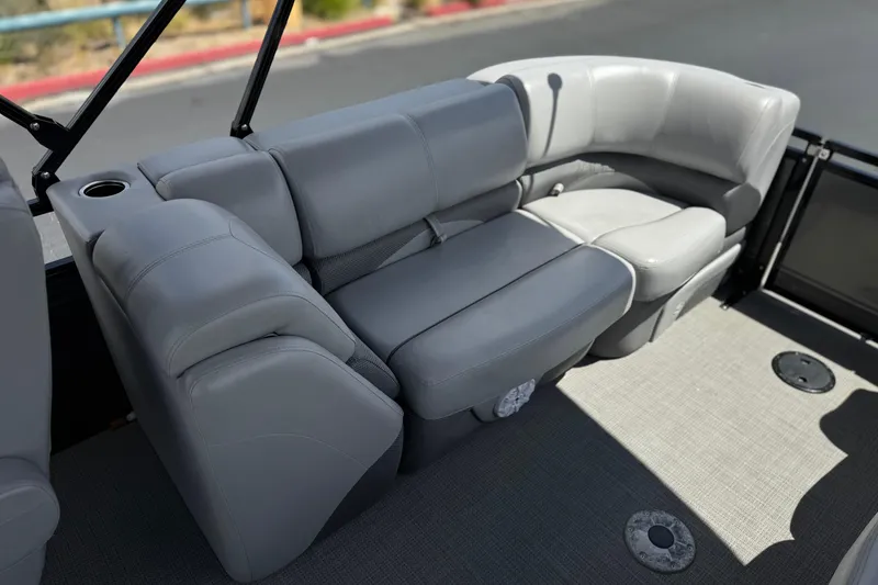 Slide: The Image of 2024 Regency 230 DL3 boat interior with gray cushioned seating and cup holder. - 19
