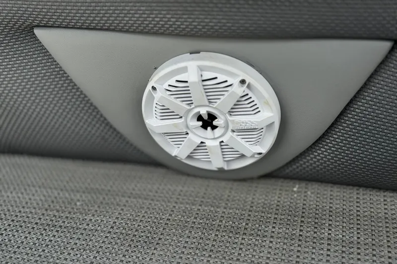 Slide: The Image of 2024 Regency 230 DL3 boat speaker on gray textured upholstery. - 21