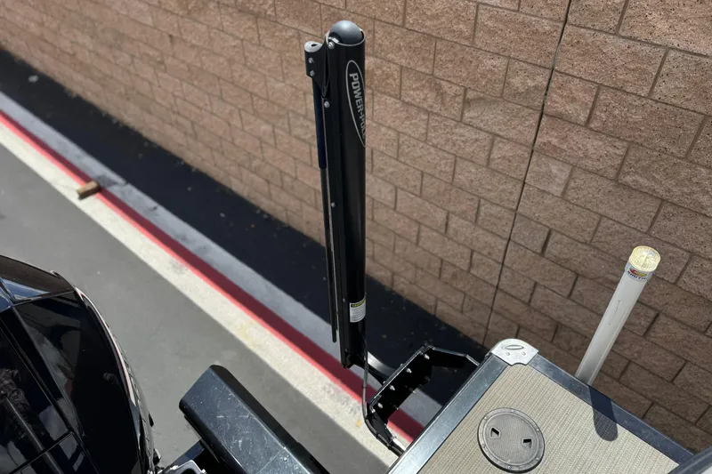 Slide: The Image of 2024 Regency 230 DL3 boat detail with Power-Pole anchor against brick wall background. - 23