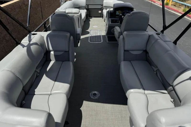 Slide: The Image of 2024 Regency 230 DL3 pontoon boat interior with gray seating and spacious layout. - 24