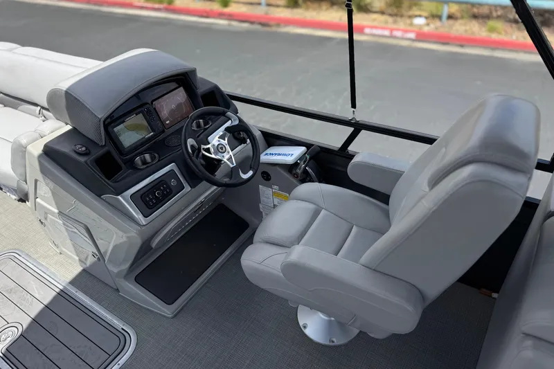 Slide: The Image of 2024 Regency 230 DL3 boat cockpit with steering wheel and control panel. - 25