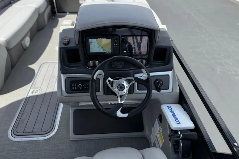 Slide: The Image of 2024 Regency 230 DL3 boat dashboard with steering wheel and navigation system. - 26