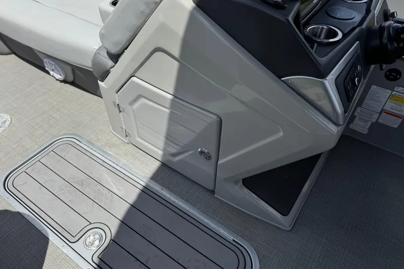Slide: The Image of 2024 Regency 230 DL3 boat interior with console, storage, and cup holders. - 29