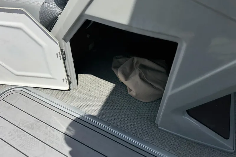 Slide: The Image of Open storage compartment in 2024 Regency 230 DL3 boat, showing interior space and flooring. - 30