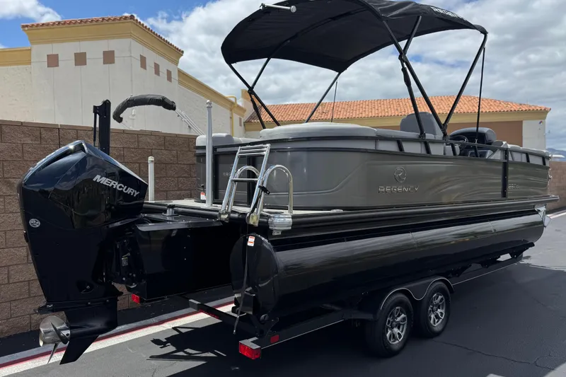 Slide: The Image of 2024 Regency 230 DL3 pontoon boat with Mercury engine, parked outdoors. - 6