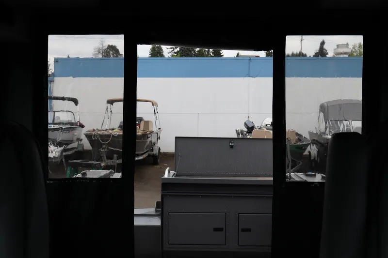 Slide: The Image of Interior view of 2026 Alumaweld Horizon 24 boat, showcasing docked vessels outside. - 24