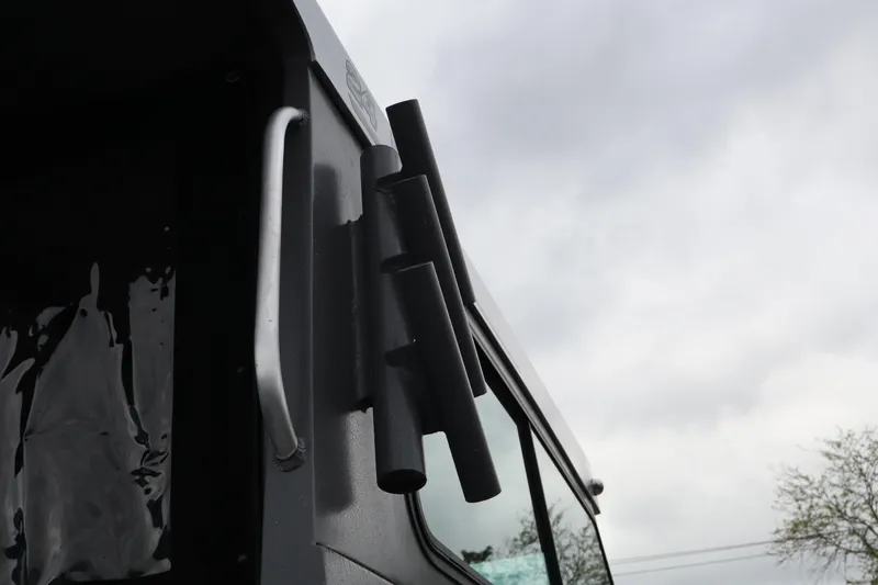 Slide: The Image of 2026 Alumaweld Horizon 24 boat exterior with rod holders against cloudy sky. - 27