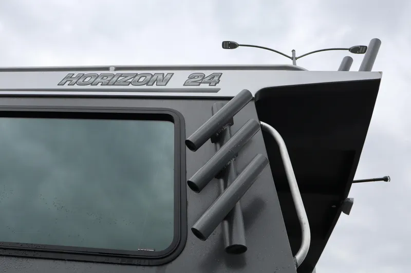 Slide: The Image of 2026 Alumaweld Horizon 24 boat detail with rod holders and window. - 28