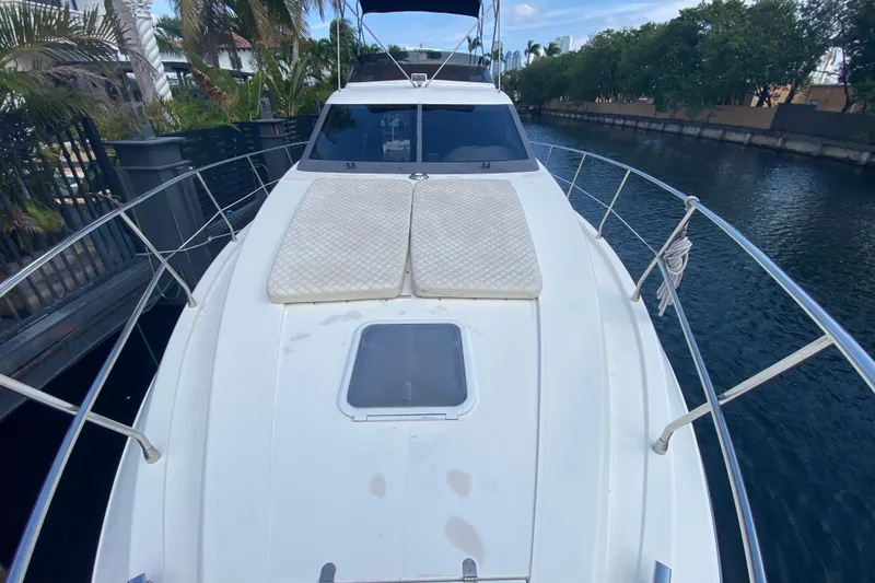 Slide: The Image of 1998 Azimut 52 yacht with sun pads on deck, docked in a canal. - 11
