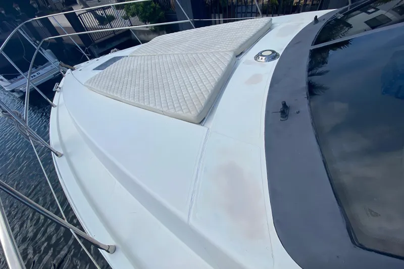 Slide: The Image of 1998 Azimut 52 yacht deck with cushioned sunbathing area, docked by the water. - 13