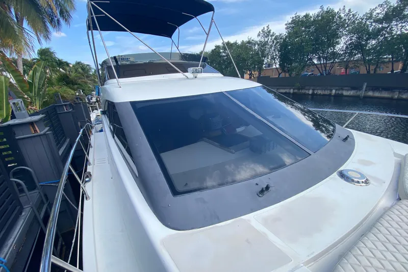 Slide: The Image of 1998 Azimut 52 yacht docked by a canal, featuring sleek design and spacious deck. - 15