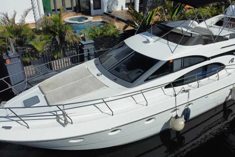 Slide: The Image of 1998 Azimut 52 yacht docked near a luxurious poolside setting. - 19
