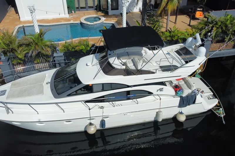 Slide: The Image of 1998 Azimut 52 yacht docked near luxurious poolside villa. - 20