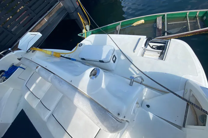 Slide: The Image of 1998 Azimut 52 yacht deck with seating and storage, docked beside a small boat. - 25