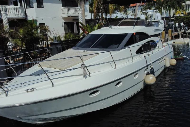 Slide: The Image of 1998 Azimut 52 yacht docked near waterfront homes, featuring sleek design and modern amenities. - 3