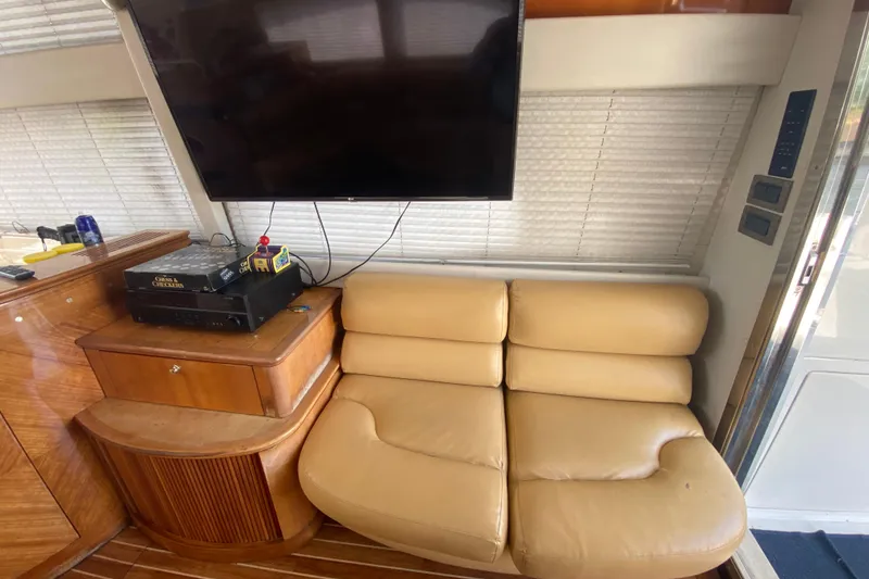 Slide: The Image of Interior of a 1998 Azimut 52 yacht with beige leather seating and a mounted TV. - 31