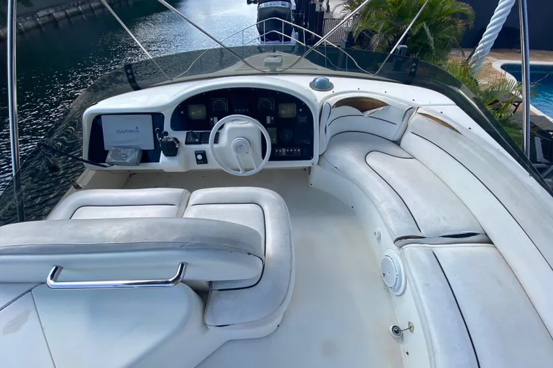 Slide: The Image of Cockpit of 1998 Azimut 52 yacht with white seating and Garmin navigation system. - 49