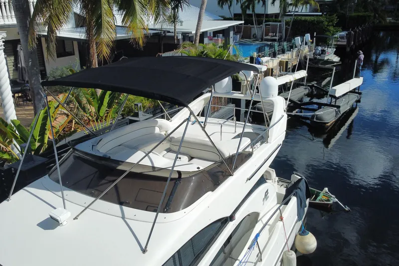 Slide: The Image of 1998 Azimut 52 yacht docked by a tropical waterfront with palm trees. - 53