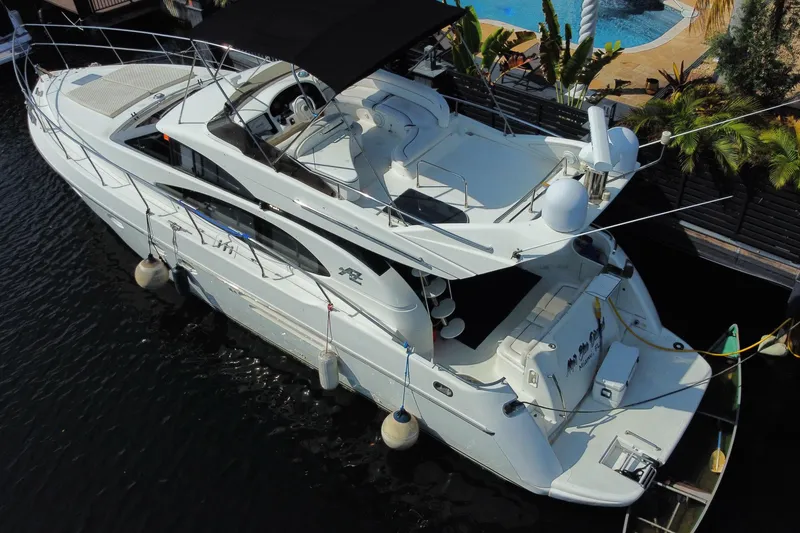 Slide: The Image of Aerial view of a 1998 Azimut 52 yacht docked by a poolside. - 58