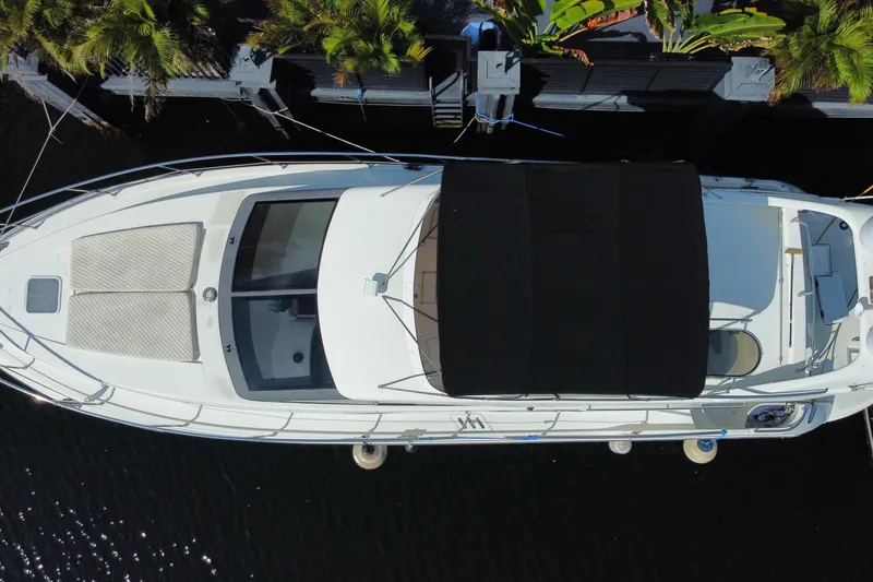 Slide: The Image of Overhead view of a 1998 Azimut 52 yacht docked near lush greenery. - 67