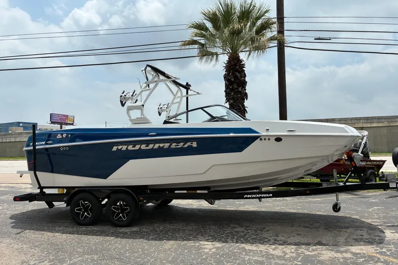The Image of 2026 Moomba Tykon boat on trailer, parked outdoors under cloudy sky. - 1