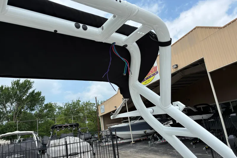 Slide: The Image of 2026 Moomba Tykon boat with white frame and exposed wires, outdoor dealership setting. - 22