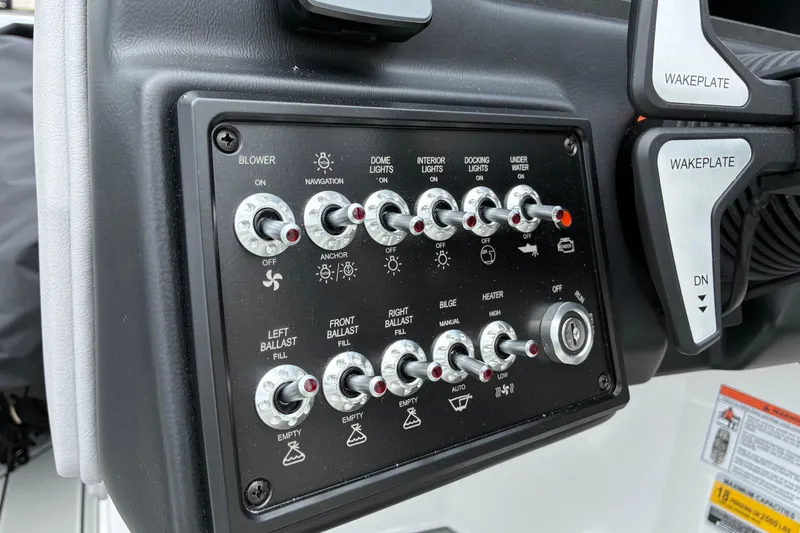 Slide: The Image of Control panel of 2026 Moomba Tykon boat with various switches and wakeplate controls. - 25