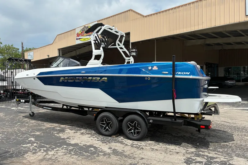 Slide: The Image of 2026 Moomba Tykon boat in blue and white on a trailer outside a building. - 5