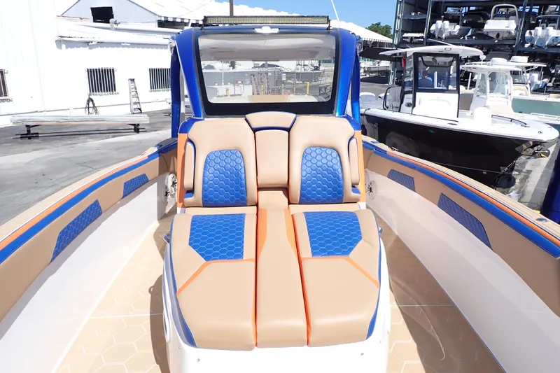Slide: The Image of 2022 Deep Impact 369 Sport boat with tan and blue seating, docked at a marina. - 11