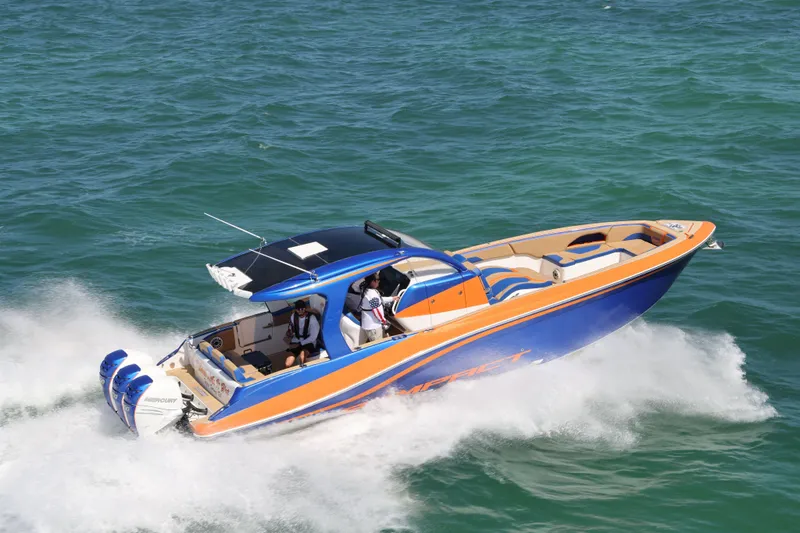 Slide: The Image of 2019 Deep Impact 369 Sport boat speeding on open water, featuring vibrant blue and orange design. - 110