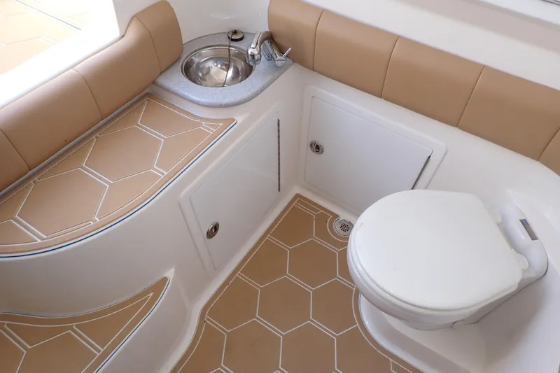 Slide: The Image of 2022 Deep Impact 369 Sport boat interior with sink and toilet, featuring tan hexagonal flooring. - 15