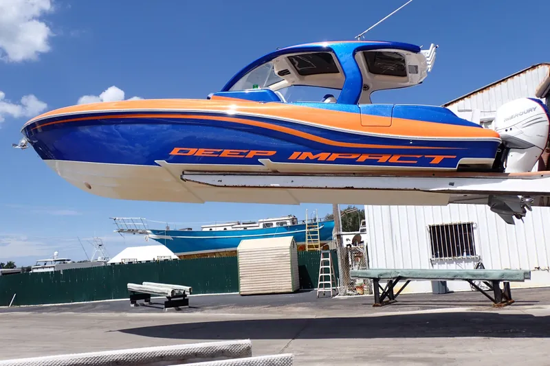Slide: The Image of 2022 Deep Impact 369 Sport boat in vibrant blue and orange, displayed outdoors. - 2